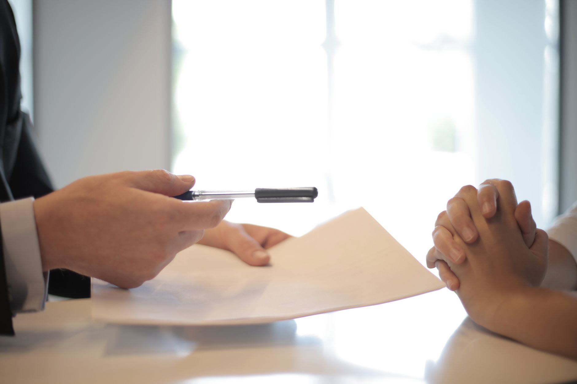 An advisor hands over a pen to sign a real-estate-backed loan contract